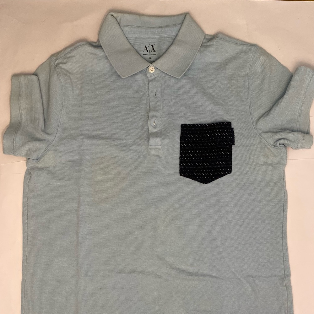 Medium polo shirt, light blue with textured navy pocket on the side